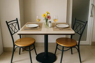 a table with two chairs and two glasses of wine at Cozy City Retreat in Ekkamai in Bangkok