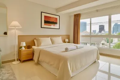 a bedroom with a large white bed and a window at Cozy City Retreat in Ekkamai in Bangkok