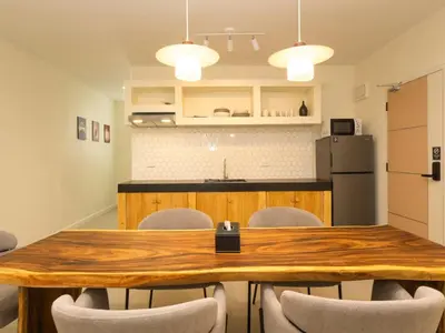 a kitchen and dining room with a wooden table and chairs at 3 Bedrooms for 5 Guests in the Heart of Sathorn in Bangkok
