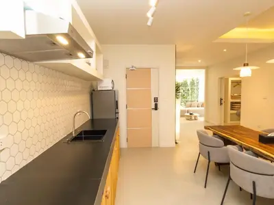 a kitchen with a counter and some chairs and a refrigerator at 3 Bedrooms for 5 Guests in the Heart of Sathorn in Bangkok