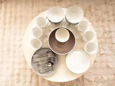 a white plate with bowls and cups on a table at Lovely Studio Room for 2 Guests in the Heart of Sathorn in Bangkok