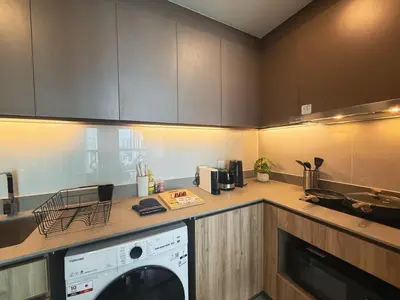 a kitchen with a washing machine on a counter at Near BTS l Workspace and Kitchen - Pool and Gym l Sontana in Bangkok