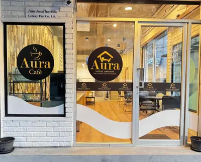 a window of an atma cafe with signs on it at Aura Hostel in Bangkok