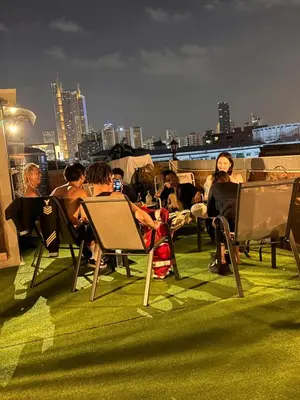 a group of people sitting in chairs on a roof at Aura Hostel in Bangkok