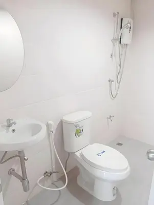 a white bathroom with a toilet and a sink at x Mirt Inn Sukhumvit II - ถนนสุขุมวิท 2 in Bang Kapi