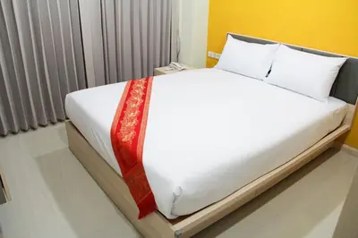 a bed with white sheets and a red tie on it at La Porte Hotel Bangkok in Bangkok