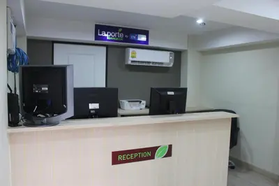a reception desk with a reputation sign on the wall at La Porte Hotel Bangkok in Bangkok