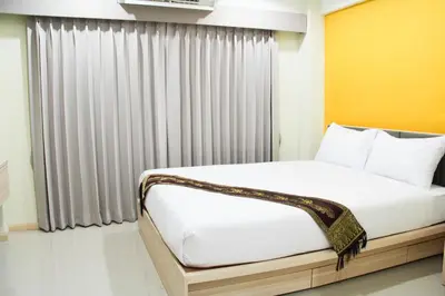 a bed in a room with a window at La Porte Hotel Bangkok in Bangkok