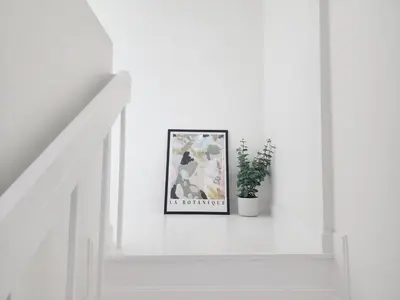 a white staircase with a picture on the wall at White House Ekkamai in Bangkok