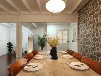 a dining room with a long table and chairs at White House Ekkamai in Bangkok