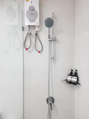 a bathroom with a shower with a shower head and a shower at White House Ekkamai in Bangkok