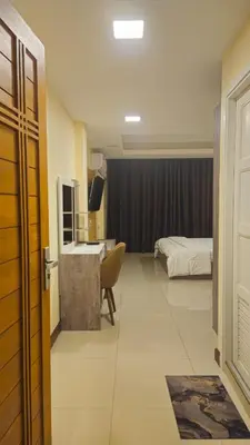 a hotel room with a bed and a desk and a bedroom at indra apartments in Bangkok
