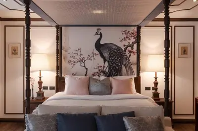 a bedroom with a large bed with a large peacock painting at Contemporary Eastern 1BR 5 min BTS| All Essential in Khlong Toei