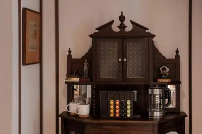 a wooden cabinet with a coffee maker on a table at Contemporary Eastern 1BR 5 min BTS| All Essential in Khlong Toei
