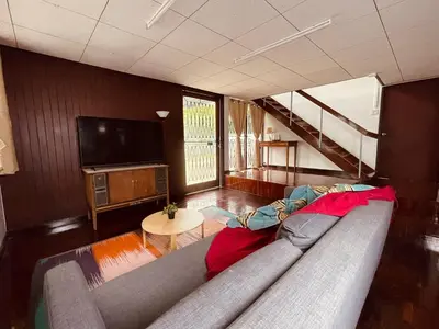a living room with a couch and a television at 4BR House max 10pax, Near MRT and Local Place