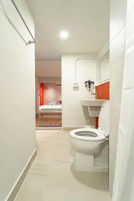 a bathroom with a white toilet and a bedroom at 2BR APT on 2nd floor for 6 ppl in Bangkok