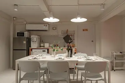 a kitchen with a white table and chairs and a kitchen with a refrigerator at 2BR APT on 2nd floor for 6 ppl in Bangkok
