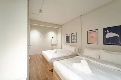 two beds in a room with white walls at A 3BR apartment for 8 pax on 3Floor in Bangkok