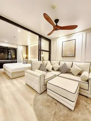 a living room with a couch and a ceiling fan at คอนโดสุขุมวิทสวีท เรียบหรู อบอุ่น ครบครัน in Makkasan