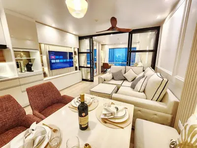 a living room with a couch and a table at คอนโดสุขุมวิทสวีท เรียบหรู อบอุ่น ครบครัน in Makkasan