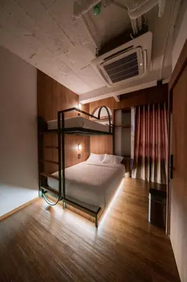 a bedroom with a bunk bed and a fan at กรุงไทย โฮสเทล สเตชั่น in Thonhuri