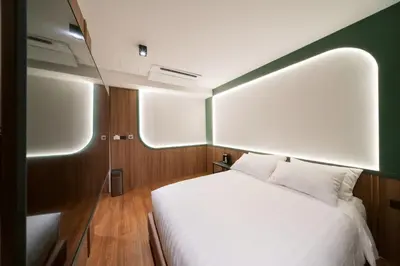 a bedroom with a white bed in a room at กรุงไทย โฮสเทล สเตชั่น in Thonhuri