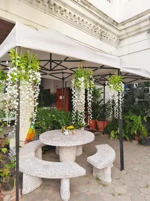 a table and two benches under an umbrella at Danita's Home Bangkok in Bangkok