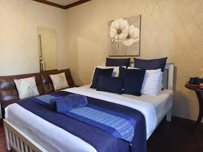 a bedroom with a large bed with blue and white pillows at Danita's Home Bangkok in Bangkok