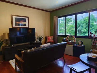 a living room with a couch and a flat screen tv at Danita's Home Bangkok in Bangkok