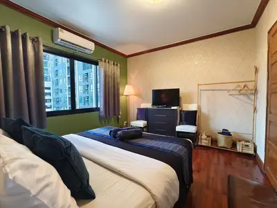 a hotel room with two beds and a television at Danita's Home Bangkok in Bangkok