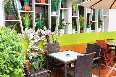 a patio with a table and chairs and plants at Lucky Green View in Bangkok