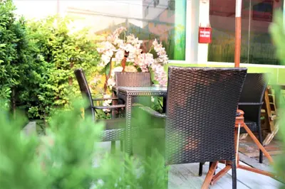 a patio with two chairs and a table with flowers at Lucky Green View in Bangkok