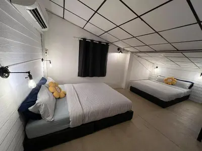 two beds in a room with white walls at LA CASA in China town in Bangkok