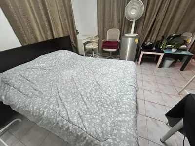 a bedroom with a bed and chairs and a fan at Wewash Room Laksi - Donmuang Airport ห้องวีวอช หลักสี่ -สนามบินดอนเมือง in Thung Si Kan