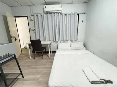 a room with a bed and a table and a chair at Wewash Room Laksi - Donmuang Airport ห้องวีวอช หลักสี่ -สนามบินดอนเมือง in Thung Si Kan
