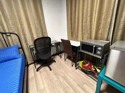 a room with a table and a tv and chairs at Wewash Room Laksi - Donmuang Airport ห้องวีวอช หลักสี่ -สนามบินดอนเมือง in Thung Si Kan