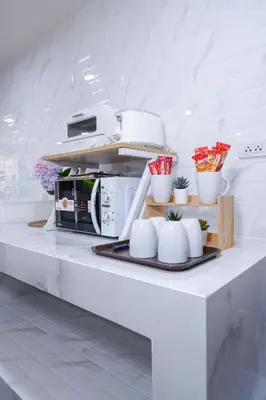 a kitchen with a white counter with a microwave at Cozy KingsizeBed เจริญนคร