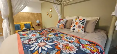 a bedroom with a bed with a floral bedspread at Hotel pretty rooms in Pak Kret