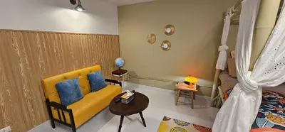 a living room with a yellow couch and a table at Hotel pretty rooms in Pak Kret