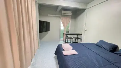 a bedroom with a blue bed with pink towels on it at TongmuanHomestay&Bar in Bangkok Noi