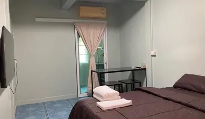 a bedroom with a bed with two towels on it at TongmuanHomestay&Bar in Bangkok Noi