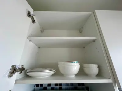 a shelf with bowls and a toilet in a bathroom at Sky View at The Parkland Ngamwongwan-Khae Rai by Orn in Nonthaburi