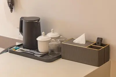 a tray with a coffee maker and a box on a counter at The Bentley Hotel in Bangkok