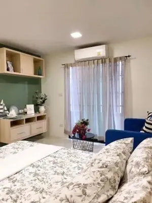 a bedroom with a bed and a blue couch and a window at Narada Residence in Pak Kret