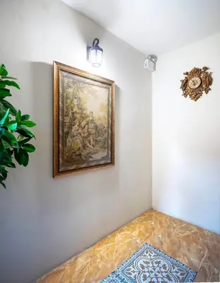 a painting hanging on a wall with a rug at Narada Residence in Pak Kret