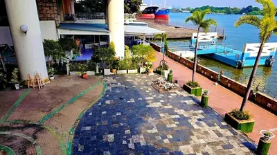 a walkway next to a marina with palm trees at River View Bangkok Apartment in Bangkok