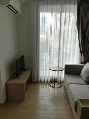 a living room with a couch and a table and a television at 1 bed apartment at Phra Khnong in Bangkok