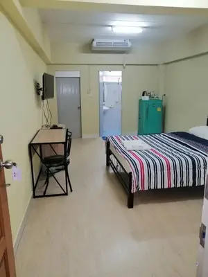 a bedroom with a bed and a table and a desk at KT MANSION Victory Monument in Bangkok
