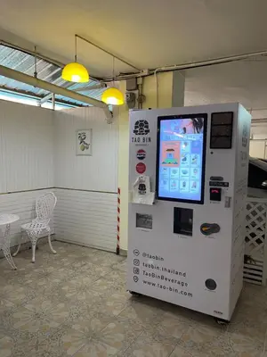 a machine with a screen in a room with a chair at KT MANSION Victory Monument in Bangkok