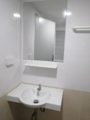 a white bathroom with a sink and a mirror at KS RESIDENCE Victory Monument in Bangkok